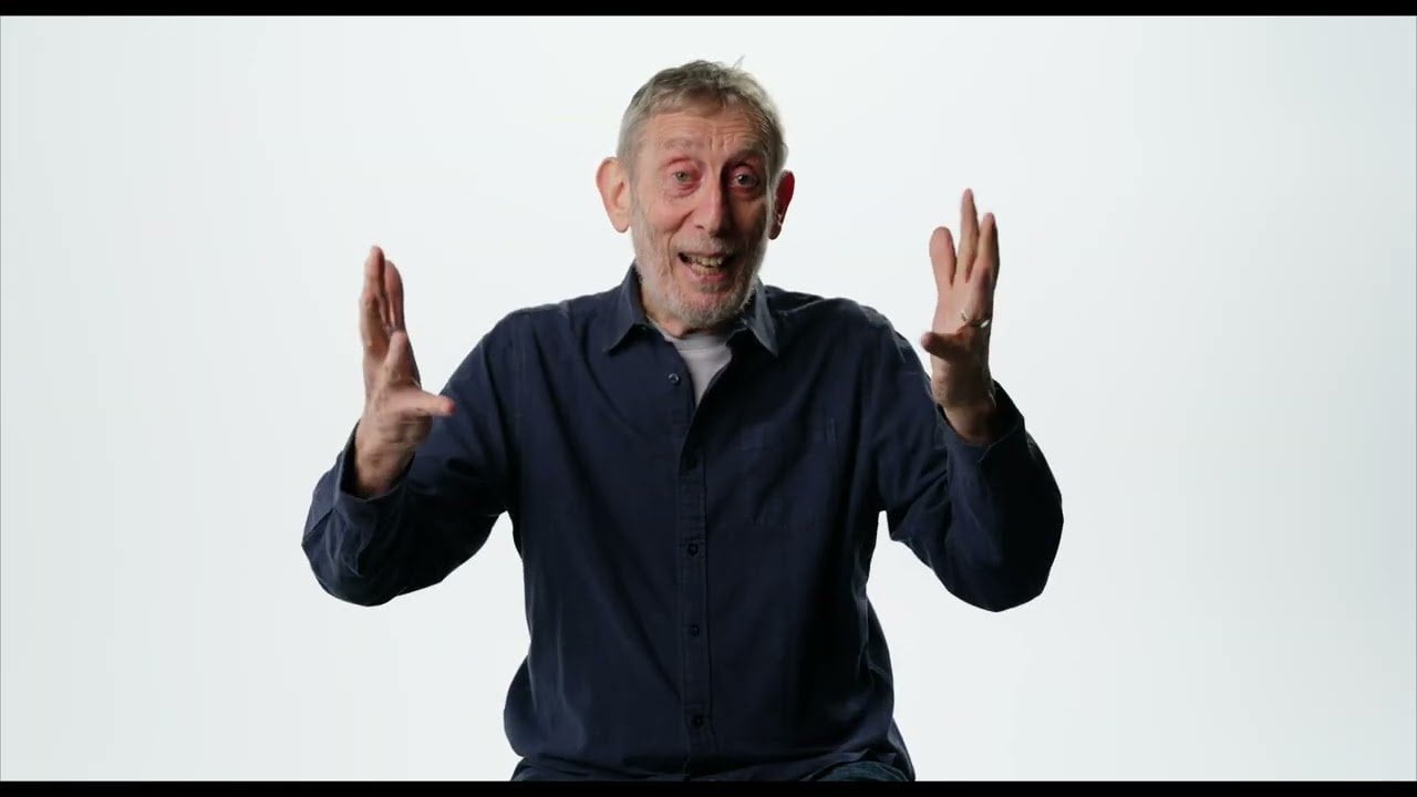 Michael Rosen smiling with hands raised