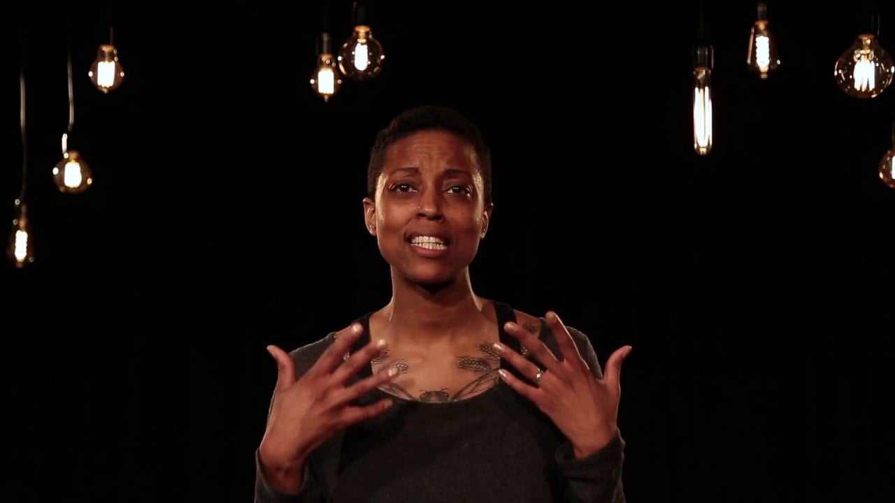 Image of a woman with short hair in a dark room with hanging lightbulbs