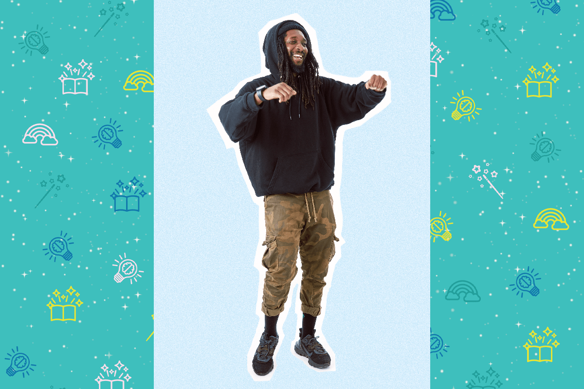 An image of poet Ehireme Omoaka. He has long black hair and wears a black hoodie and Green trousers. He is smiling in the image.