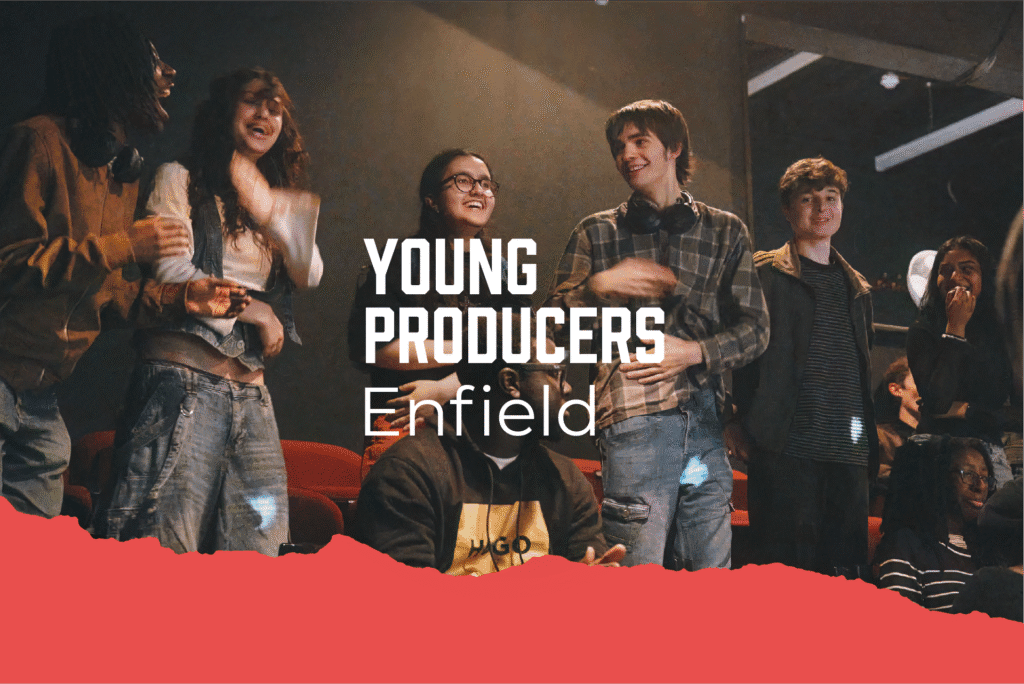 A group of young adults smiling together in a theatre setting